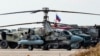 A Russian Air Force Kamov Ka-52 Alligator military attack helicopter is pictured with other trucks and vehicles at the Russian airbase at Qamishli Airport in northeastern Syria on December 12, 2024.