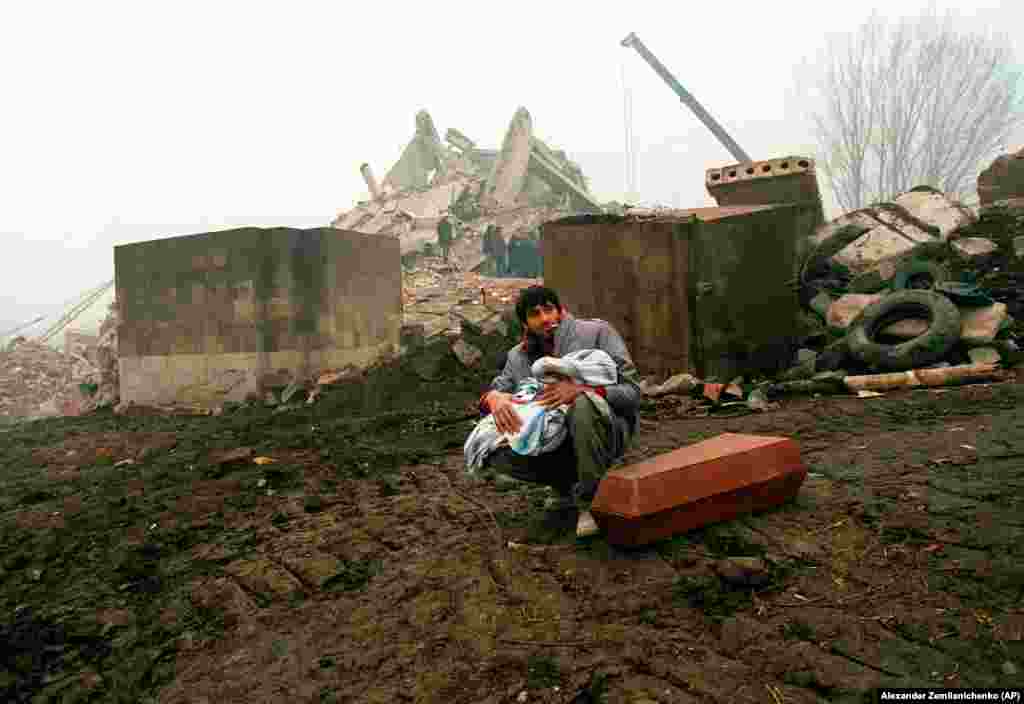 Мужчина держит тело своего ребенка. Гюмри, 7 декабря 1988 года