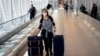 FILE PHOTO: A woman wears a face mask as she exits one of the terminals at the John F. Kennedy International Airport in New York, U.S., March 9, 2020. REUTERS/Eduardo Munoz/File Photo - RC27HF9XT8FZ